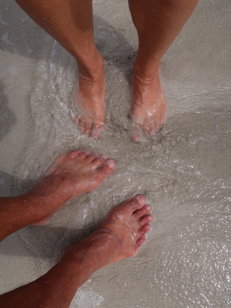 We feel the sand between our toes.